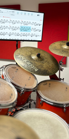 Drumset mit Notenanzeige auf einem Monitor im Unterrichtsraum